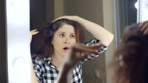 Woman Shocked by Gray Hair in Mirror