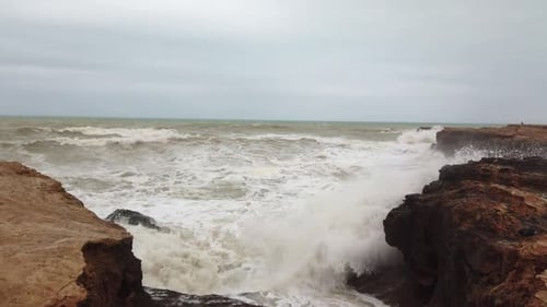 Cámara lenta de una ola marina extrema contra la roca del océano
