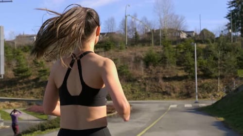 Woman Running in Park on Sunny Day