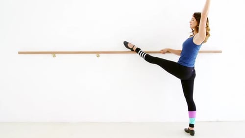 Woman Stretching Leg at Ballet Barre