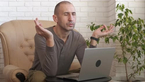 Man Meditating Before Using Laptop Indoors