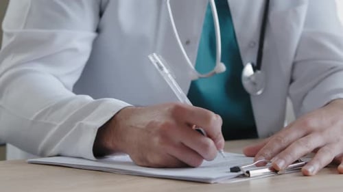 Unbekannter Mann Doktor Junger männlicher Therapeut in weißer Uniform sitzen am Kliniktisch Schreiben detailliert