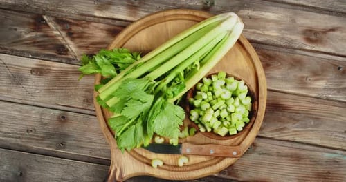 Fresh Celery on Wood Board with Knife