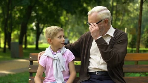 Grandfather and Grandson Talking on a Park Bench