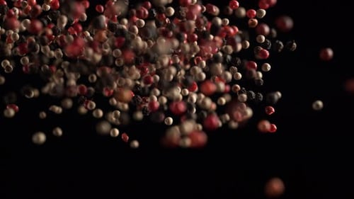 Peppercorns Falling in Brightly Lit Close Up Shot