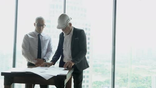 Architects Reviewing Plans in Modern Office Building