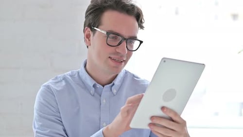 Portrait d'un jeune homme joyeux utilisant une tablette