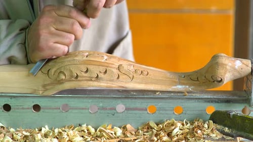 Hands Carving Intricate Wood Design