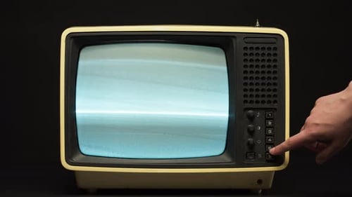 Hand Adjusts Channels on Retro Television Set