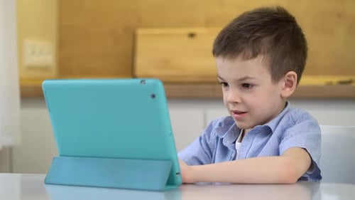 Young Boy Using Tablet at Table Indoors
