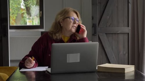Woman on Phone with Laptop at Home