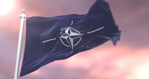 Realistic NATO Flag Waving Against a Cloudy Sky