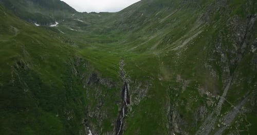cinematic view of waterfall in green mountains valley