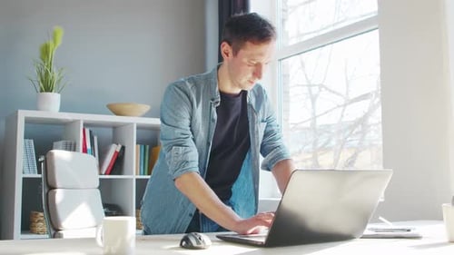 Young male entrepreneur works at home office at the computer.