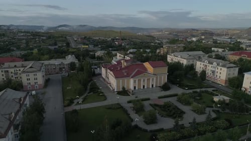 Aerial view of beautiful house of culture square and alley. People walk, cars drive on roads 13