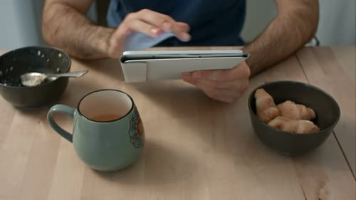 Man Using Tablet at Table with Breakfast