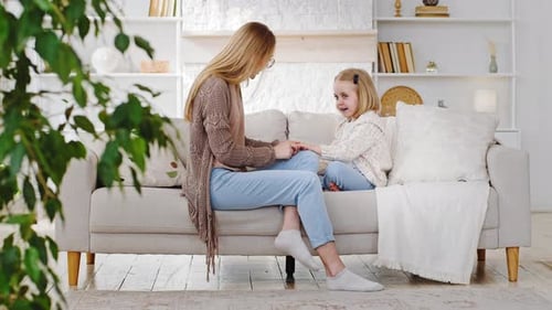 Woman and Child Conversing on Sofa Indoors