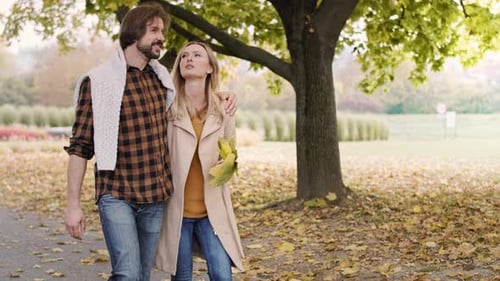 Fröhliches Paar spaziert im Herbstpark