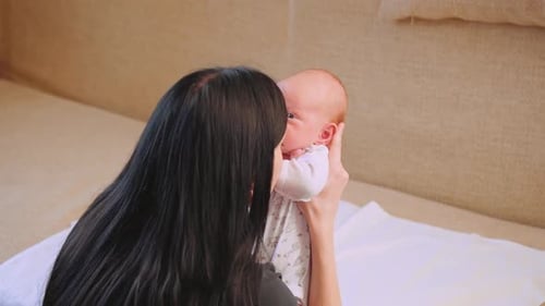 Loving Mother Holding Newborn Baby Indoors