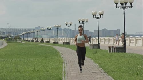 Young Woman Runner Running on City Bridge Road