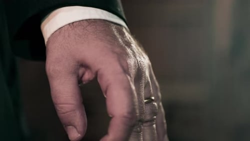 Caucasian man in suit clenching hands into fist, super close up on hands.