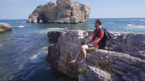 Young man watching the ocean.