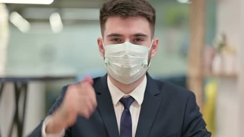 Young Adult in Suit and Mask Gives Thumbs Up