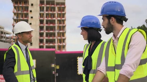 Construction Crew Discussing Building Plans on Site