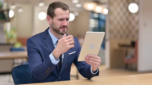 Worried Man Using Tablet Device in Office