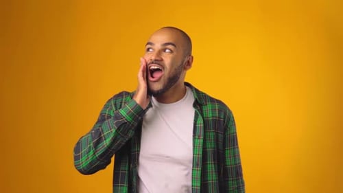 Man Reacting With Surprise Against Yellow Backdrop