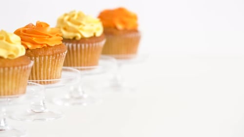 Cupcakes with Yellow and Orange Frosting on Pedestals
