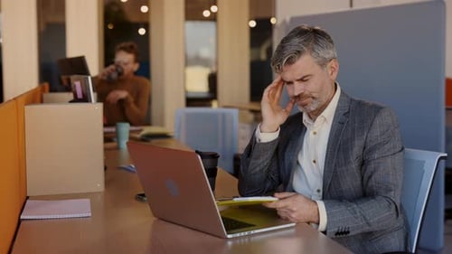 Portrait of Aucasian Businessman Working on a Laptop in the Office Having a Terrible Headache During