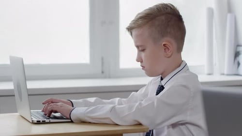 Kaukasischer Schüler erledigt Aufgaben auf dem Laptop im Unterricht