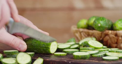 Avec la main d'un couteau, coupez le concombre en morceaux ronds et lisses.