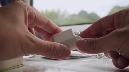 Hands Holding Wireless Earbud Case and Accessories