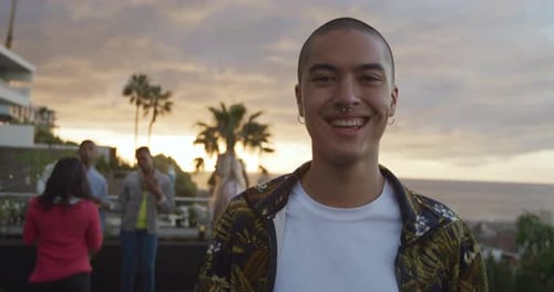 Smiling Young Adult at Rooftop Party at Sunset
