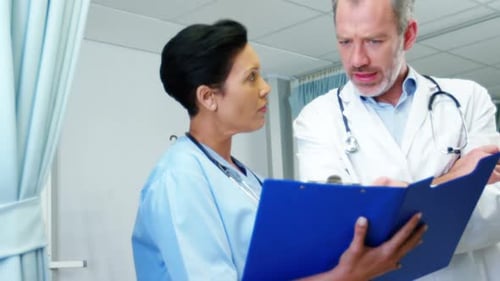 Medical Staff Reviewing Chart in Hospital Setting