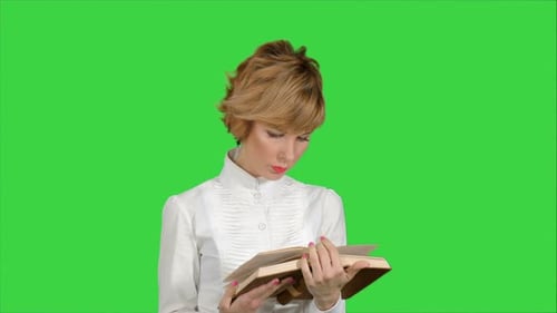 Concentrated Young Business Woman Holding and Reading Book on a Green Screen, Chroma Key