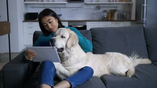 Woman Relaxing with Golden Retriever on Couch