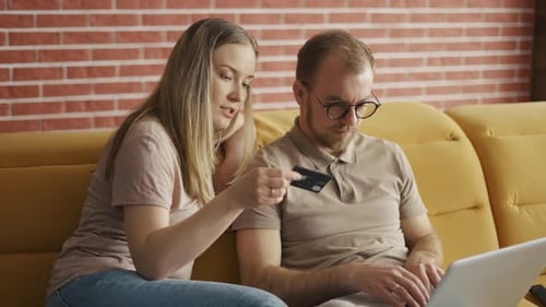 Couple Shops Online Using Laptop at Home