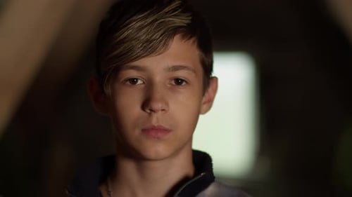 Portrait of a Sad Serious Boy Looking at the Camera, Indoors, Moving Camera