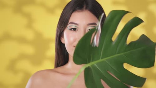 Beautiful Woman Posing With Tropical Leaf in Studio