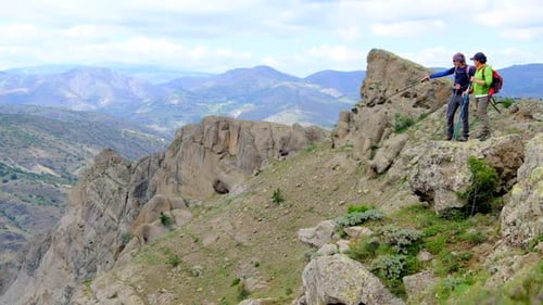 Hikers on Rocky Mountain Overlook on Sunny Day