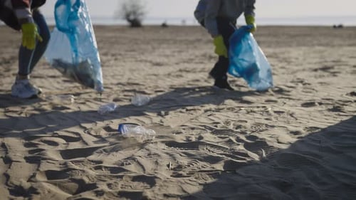 Eine Gruppe von Freiwilligen sammelt recycelbaren Kunststoff am Strand