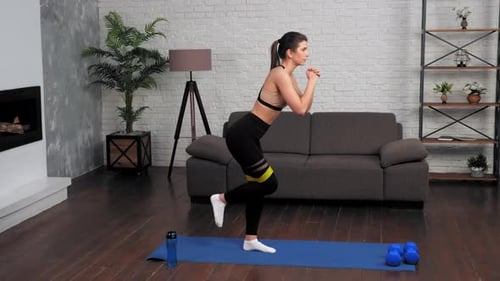 Woman Working Out at Home with Exercise Band
