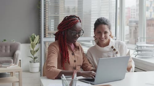 Deux collègues féminines diverses travaillant au bureau