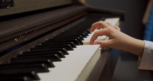 Child Hand Playing Piano Keys Close Up