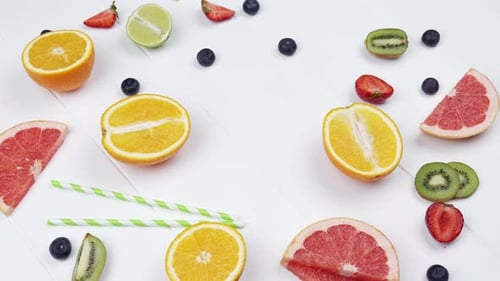 Assortment of Bright Sliced Fruit on White Table