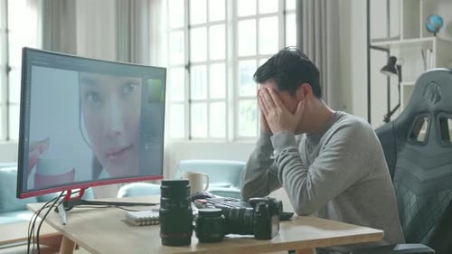 Tired Photo Editor Rubbing Face at Computer