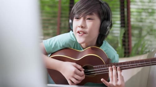 Enthusiastic Boy Plays Ukulele and Sings Along
